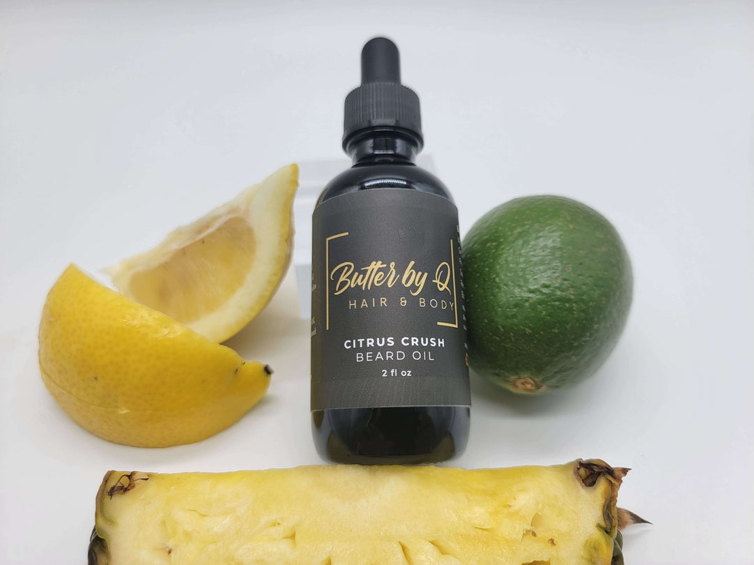 Butter by Q's 2 oz Citrus Crush Beard Oil staged with lemons, limes, and pineaples. It's made form 100% natural ingredients. 